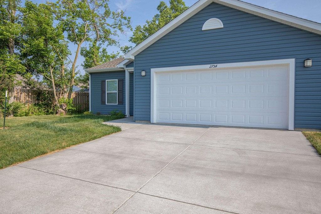 A blue house with a white garage door.