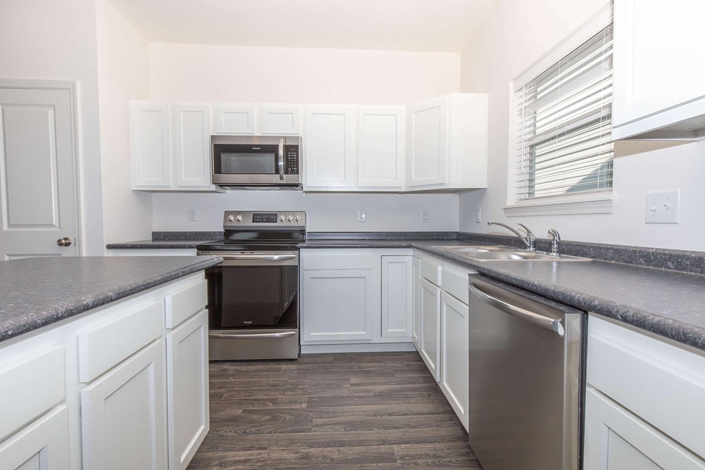 A kitchen with white cabinets and a stainless steel dishwasher.
