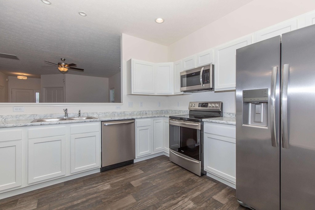 A kitchen with white cabinets and stainless steel appliances.