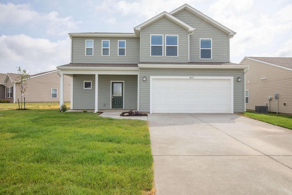 A two-story house with a garage door.