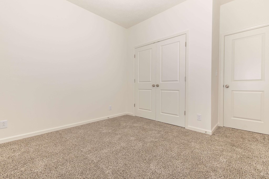 A room with a carpeted floor and white walls.