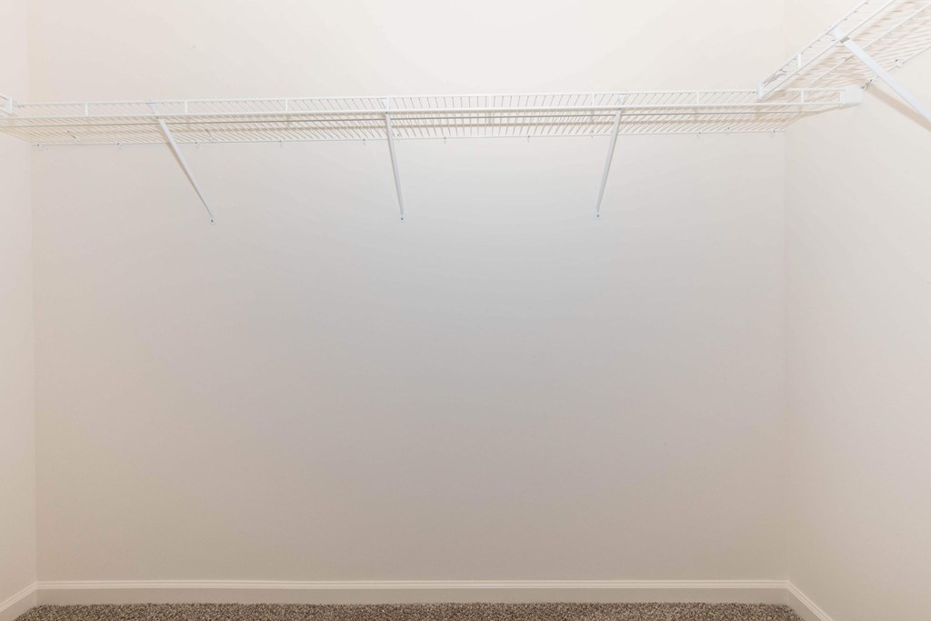 Empty white room with a shelf on the wall.