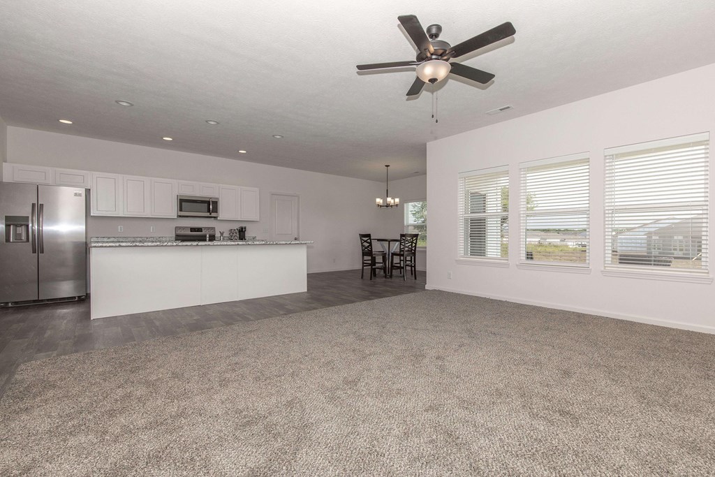 A spacious kitchen with a fan on the ceiling.