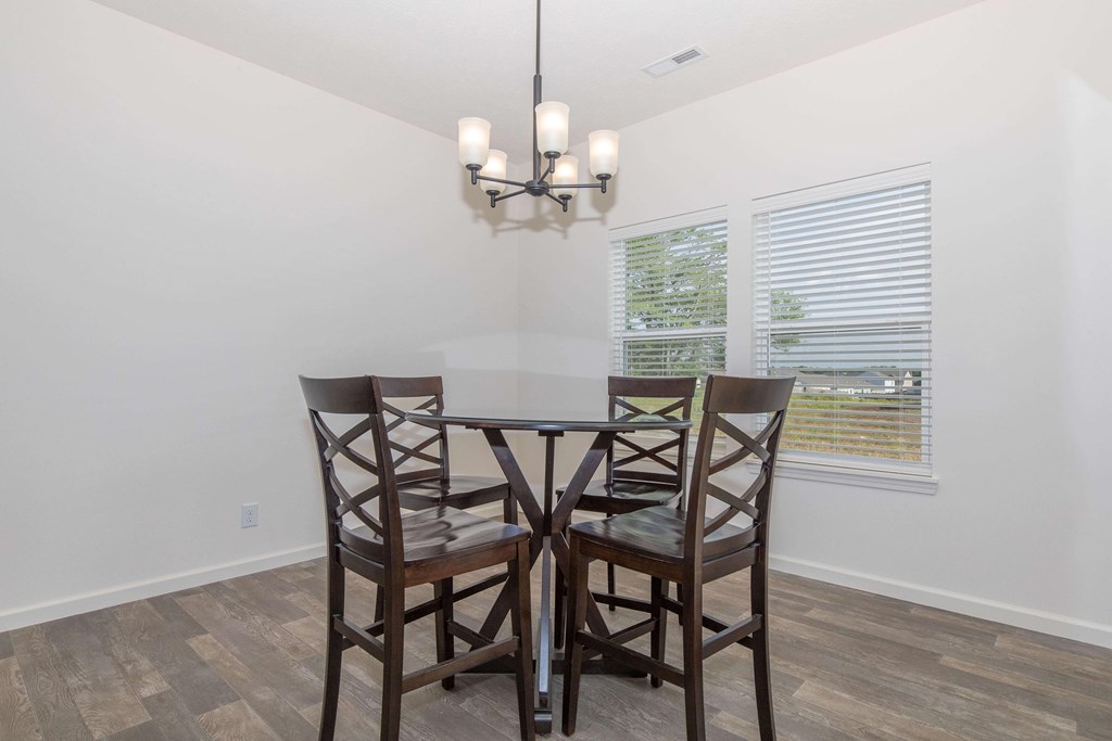 A dining room with a table and chairs.