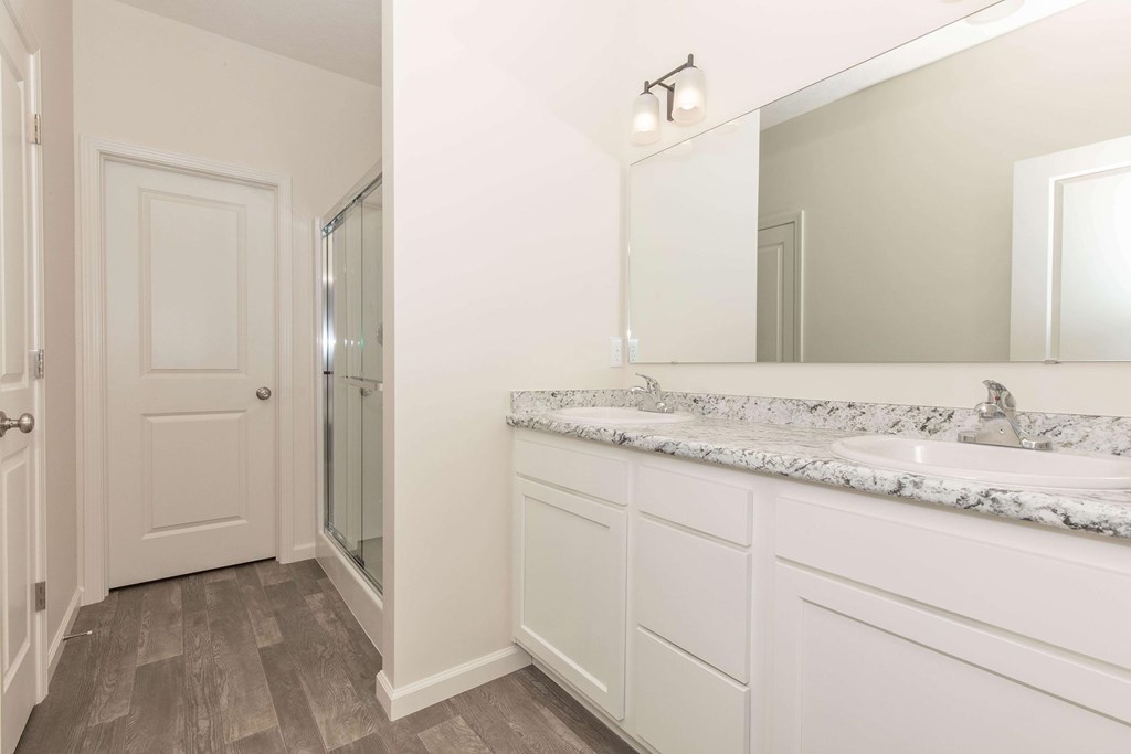 A bathroom with a marble countertop and a large mirror.
