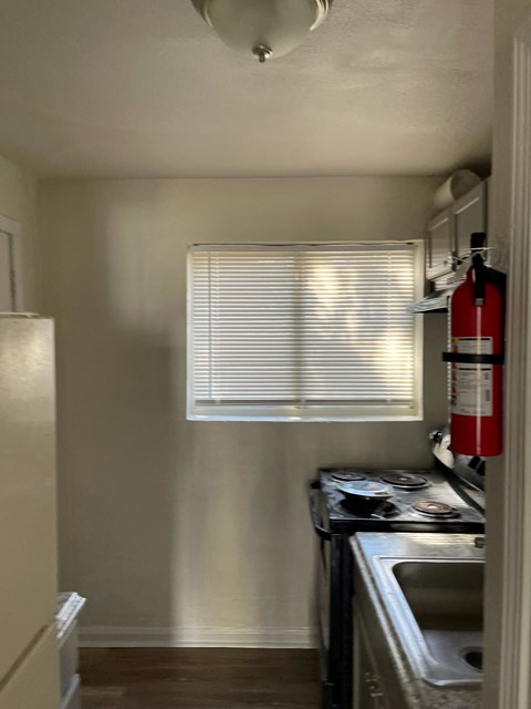 a kitchen with a stove and a sink and a window