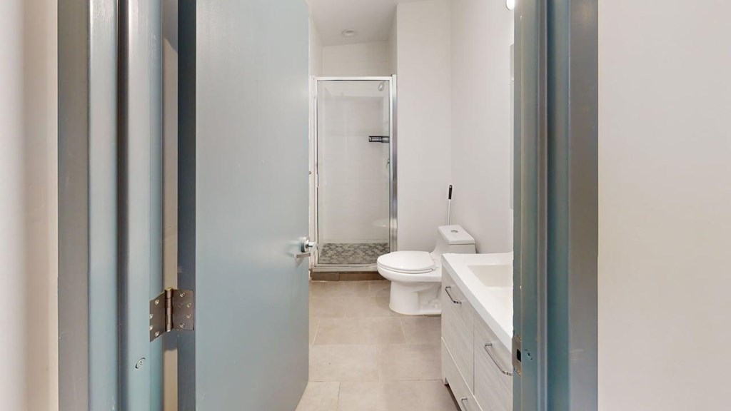 A bathroom with a toilet, sink, and shower.