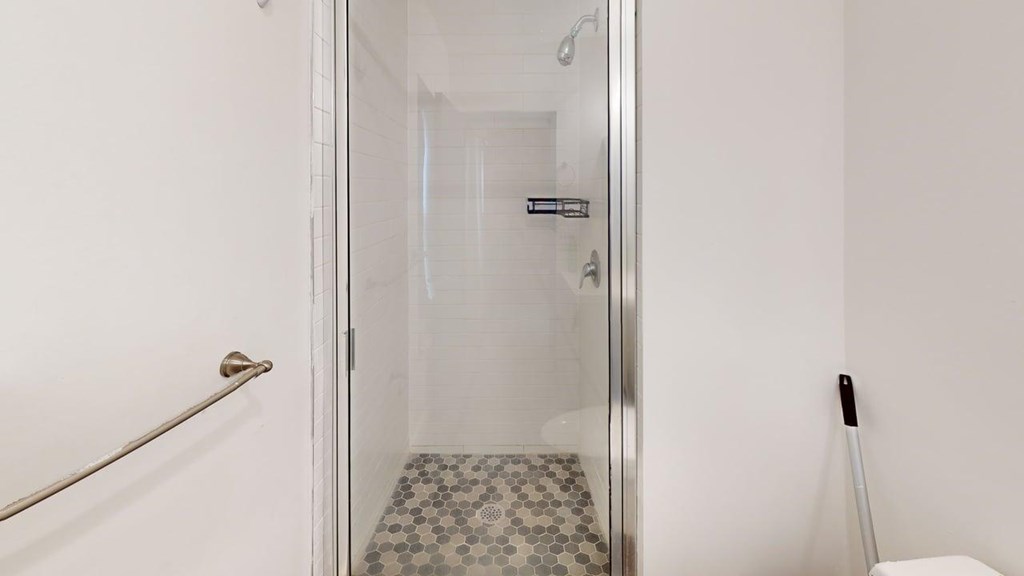 A white bathroom with a glass shower door.