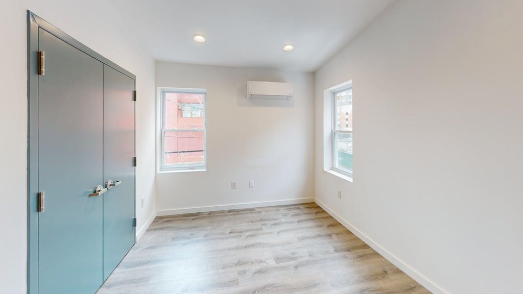 A room with a blue door and a window.