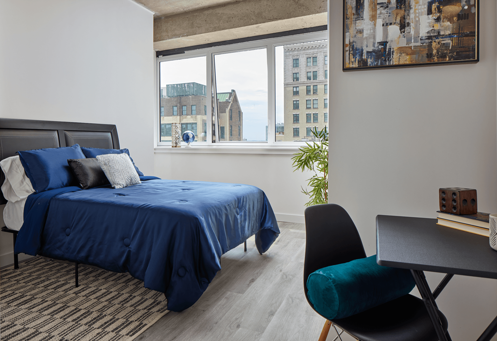 A bedroom with a large bed and a chair.