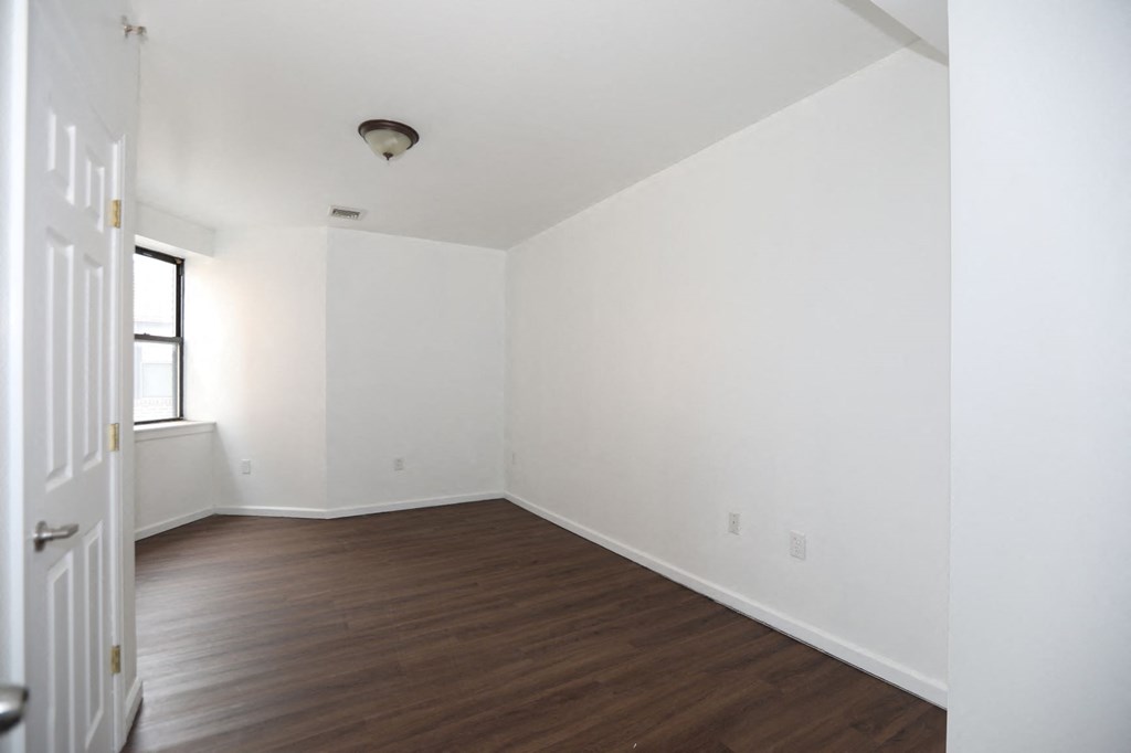 an empty living room with white walls and wood floors