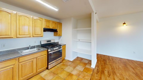 A kitchen with wooden cabinets and a tile floor.