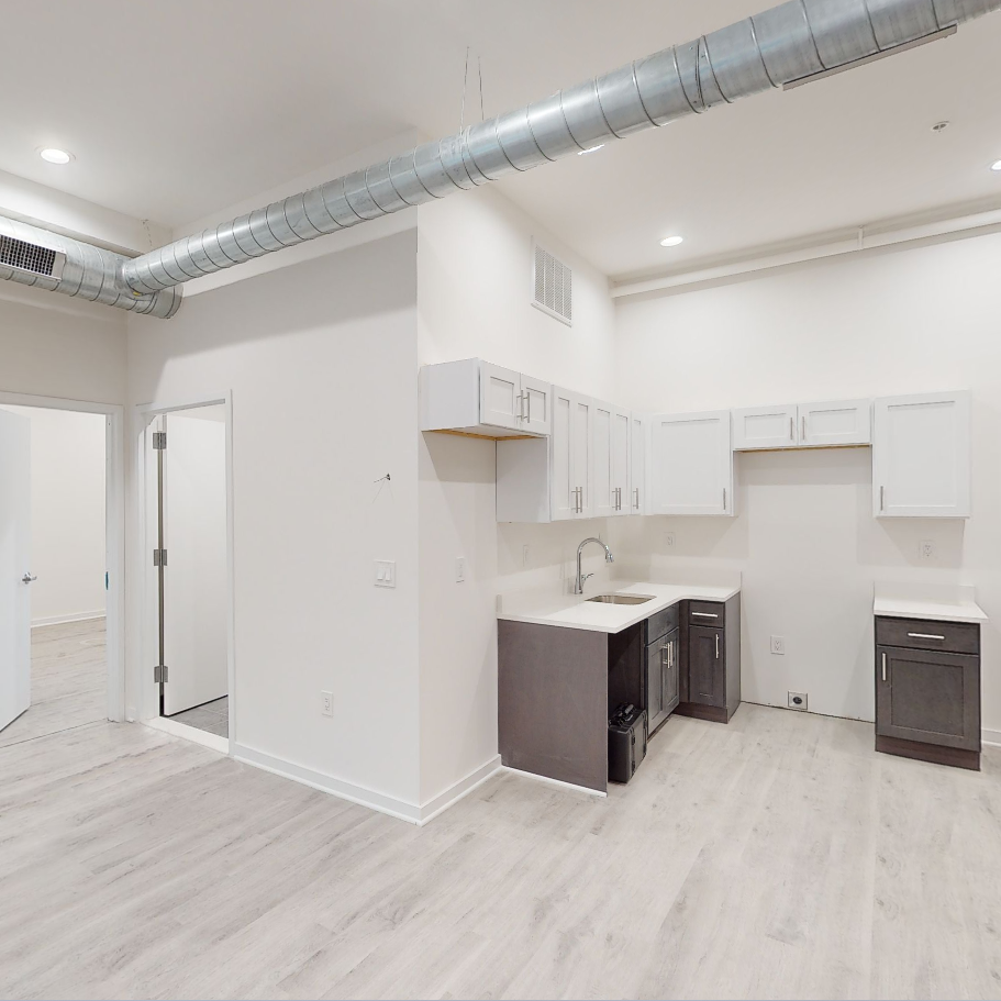 a renovated kitchen with white walls and white cabinets