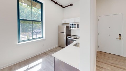 A kitchen with white cabinets and a window.