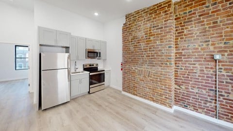 a kitchen with a brick wall and a refrigerator