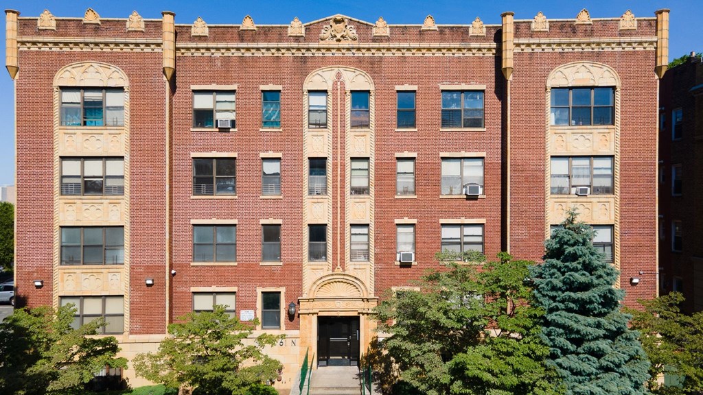 a large brick building with trees in front of it