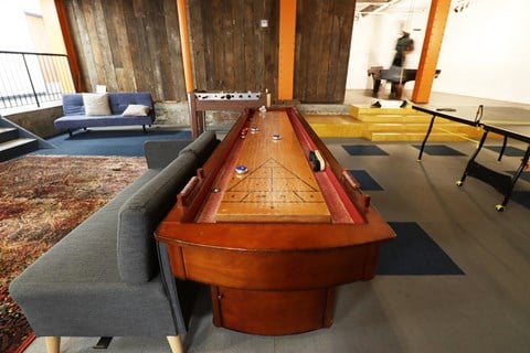 a shuffleboard table in a living room with couches