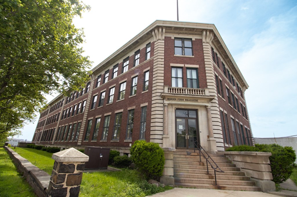 a large brick building with a staircase in front of it