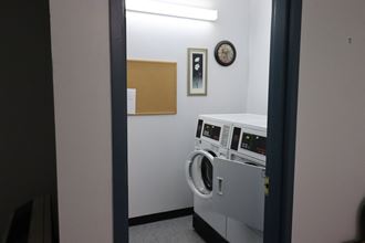 a laundry room with a washing machine and a clock on the wall