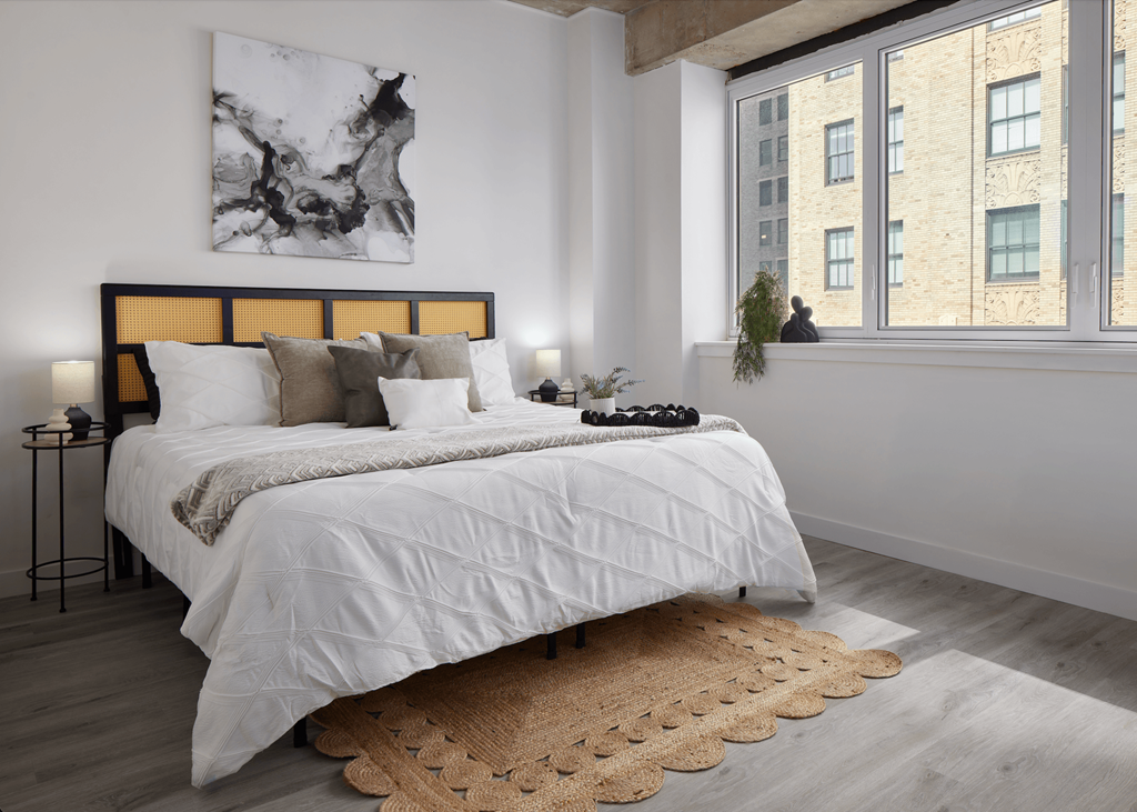 A bedroom with a large bed and a large window.