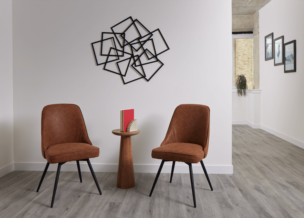 Two brown chairs are facing each other with a small table in between.