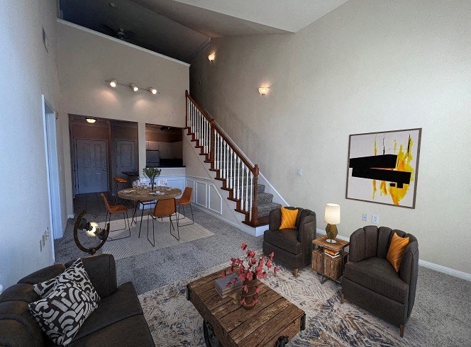 a living room and dining room with a staircase