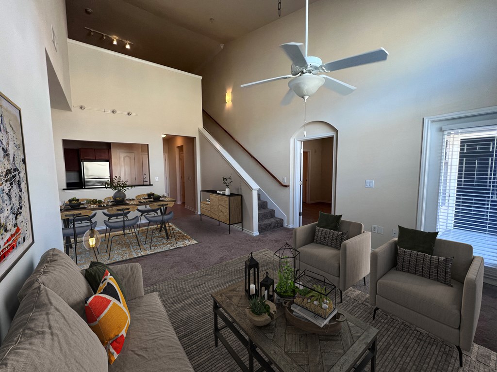 a living room with couches and a table and a ceiling fan