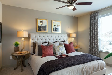A bedroom with a large bed and a ceiling fan.