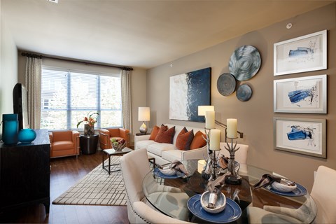 A modern living room with a glass table and a sofa.
