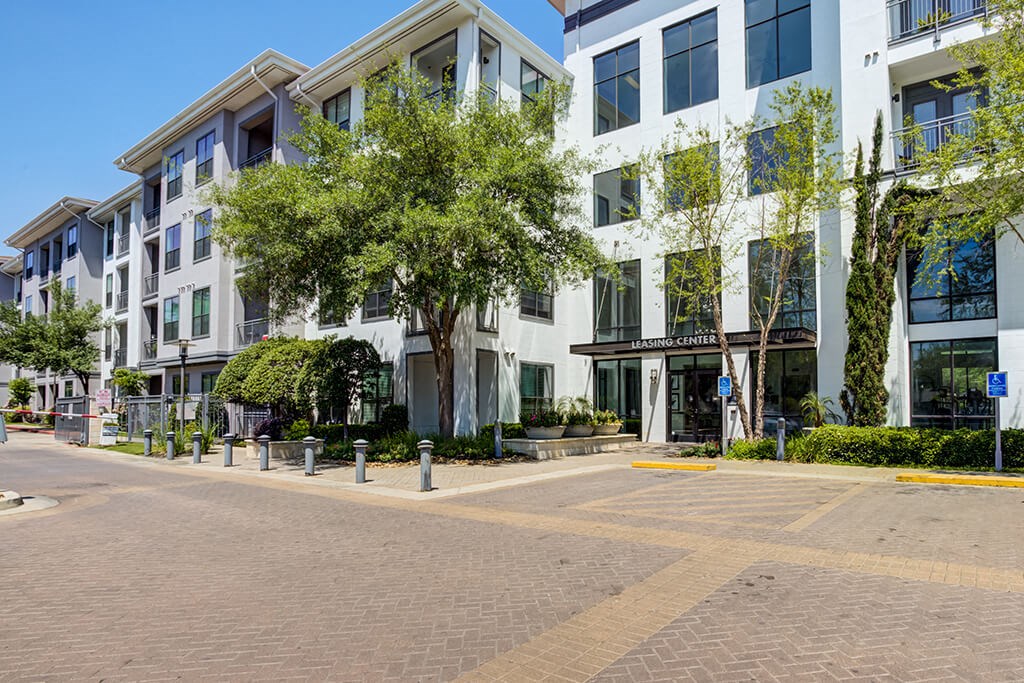 a building with a street and trees in front of it