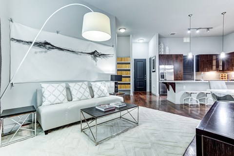 A modern living room with a white sofa and a glass coffee table.