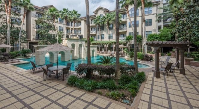 a large swimming pool in front of an apartment building