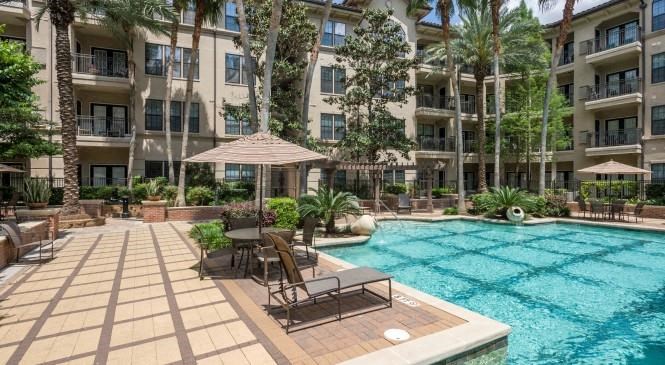 a large swimming pool in front of an apartment building