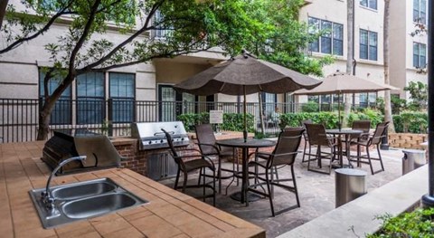 a patio with tables and chairs and a sink