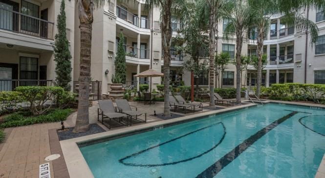 a large swimming pool in front of an apartment building