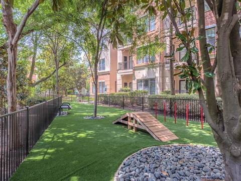 a playground and a picnic table in a yard in front of an apartment building