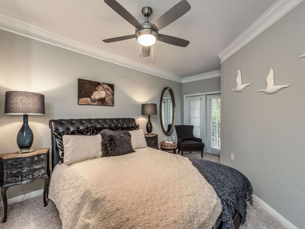 a bedroom with a large bed and a ceiling fan