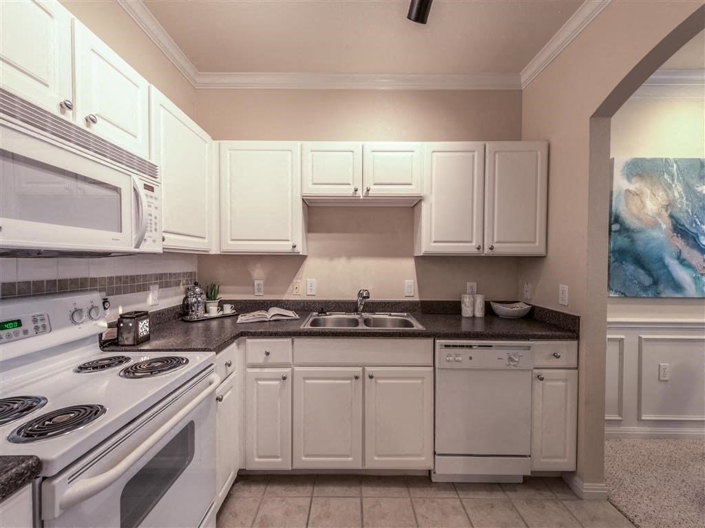 a kitchen with white appliances and white cabinets