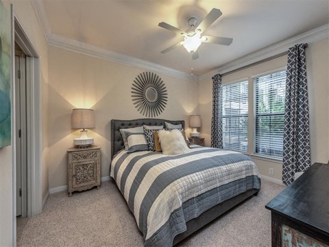 a bedroom with a bed and a ceiling fan