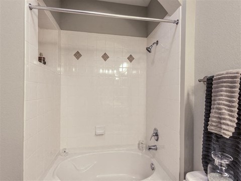 a white bathroom with a shower and a tub
