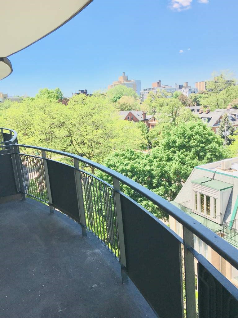 a balcony with a view of a city and trees