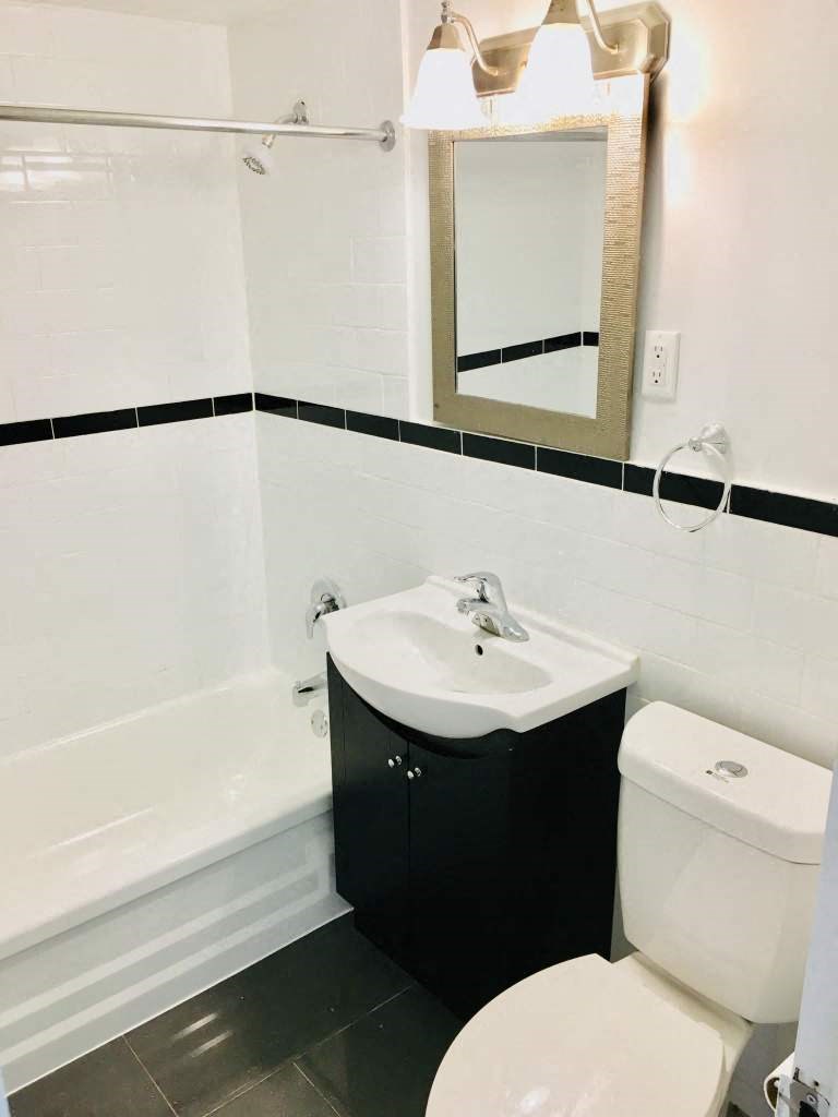 a bathroom with a toilet and a sink and a tub