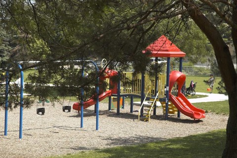 a playground with a swing set and slides in a park