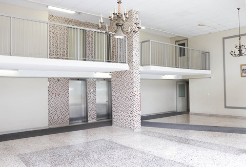 the lobby of a building with pillars and a chandelier