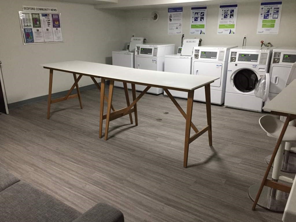 a group of washing machines and a table in a room