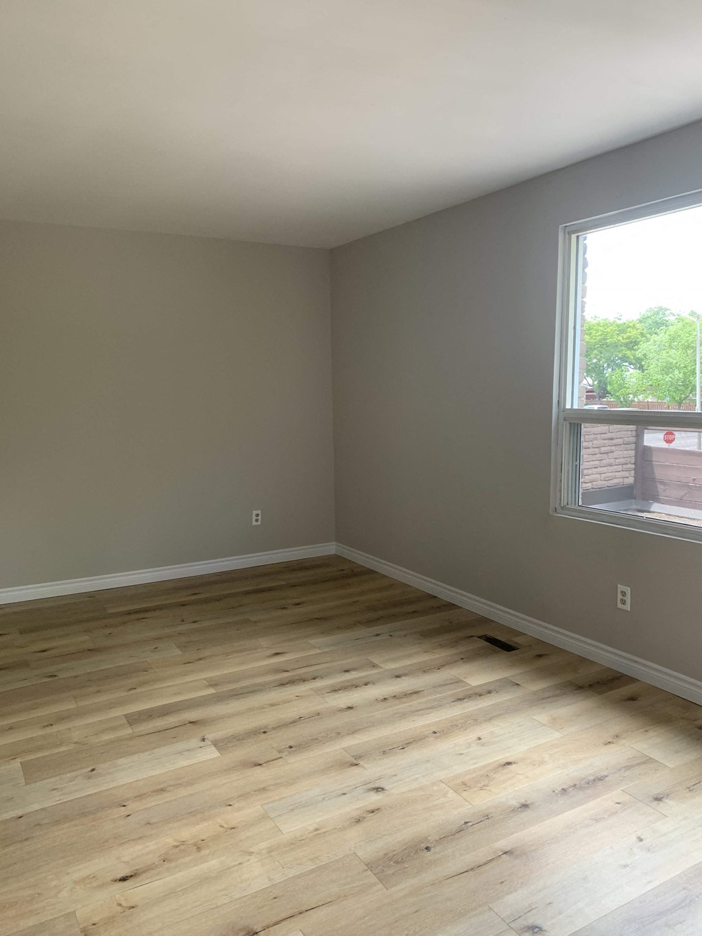 an empty room with wooden floors and a window