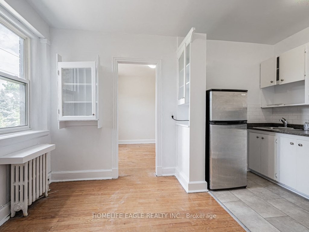 a kitchen with white cabinets and a refrigerator