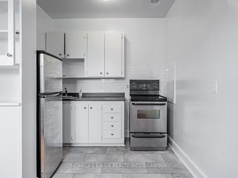 a kitchen with white cabinets and a stove and a refrigerator