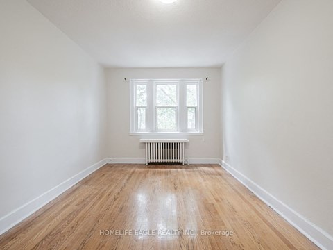 a empty room with wood floors and a window