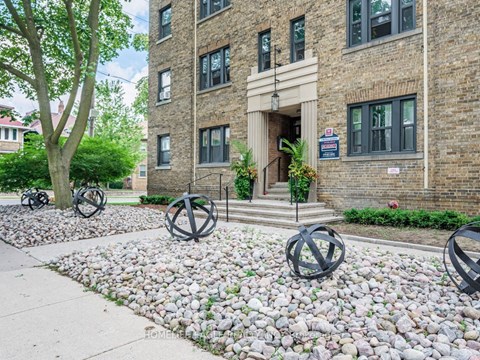 the front of a brick building with some rocks in front of it